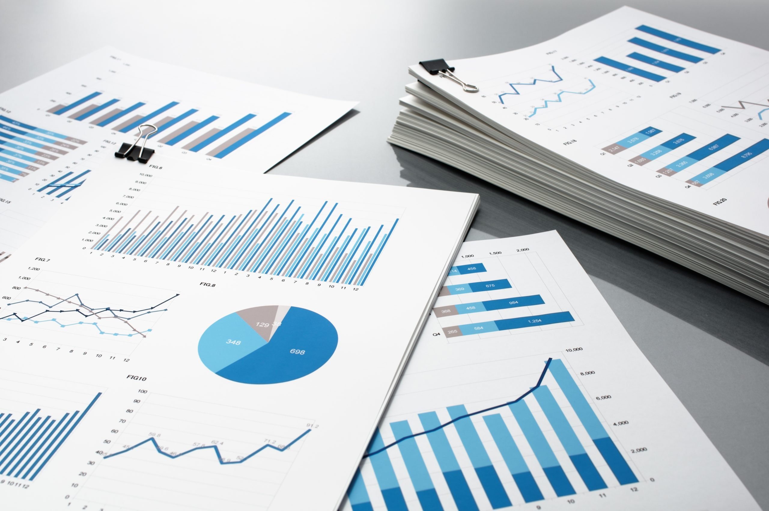 documents with charts stacked on a table