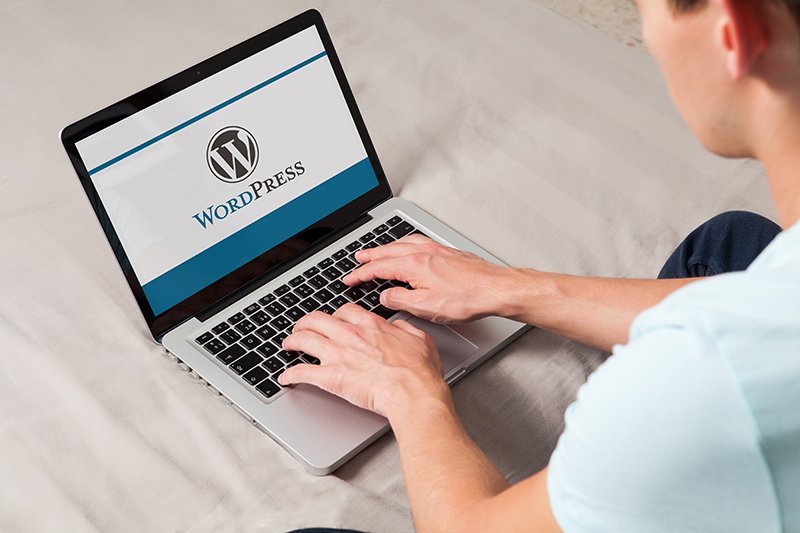 Man using a laptop with WordPress on the screen