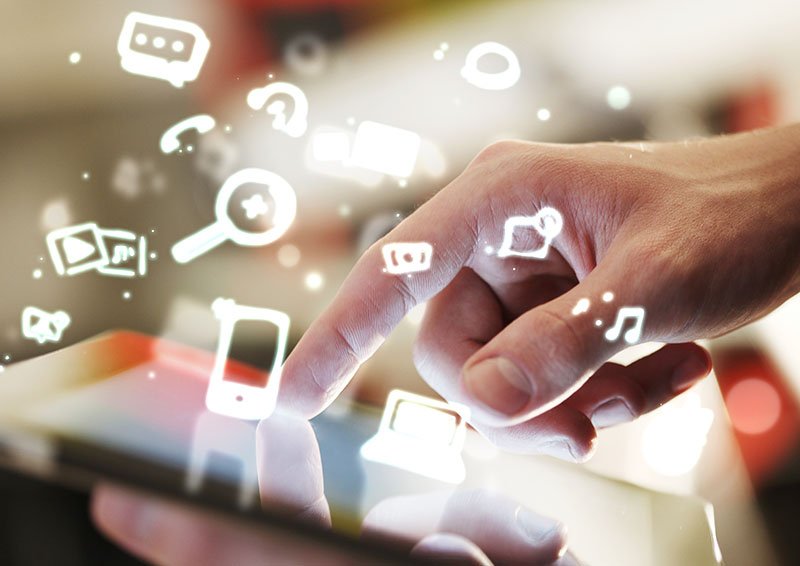 Finger pointing on tablet pc with a virtual screen showing various digital marketing channel icons