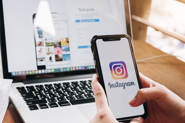 person using Instagram app on phone and Instagram on desktop