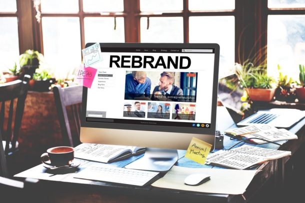 Photo of hands with phone with the word rebrand and icons