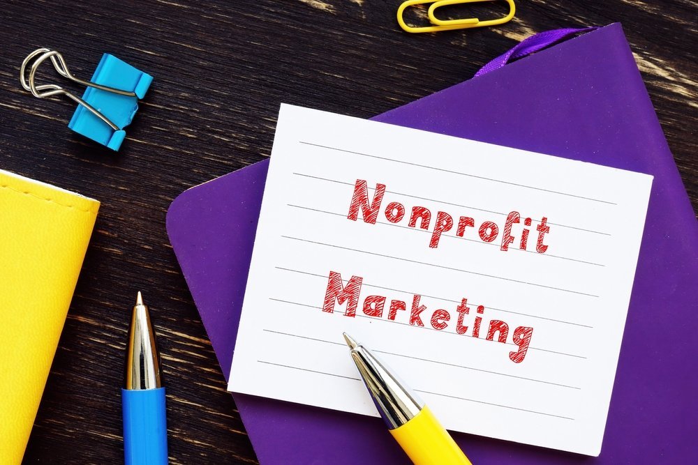 Nonprofit marketing phrase written in red on a notebook page