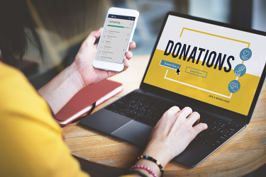 Women on computer and mobile phone making donation to children cancer institute